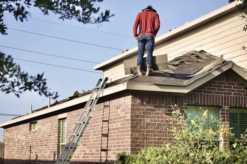 Professional roofer working on a residential roof in Noyack